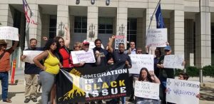 Demonstrators hold a sign that reads "Immigration is a Black issue."